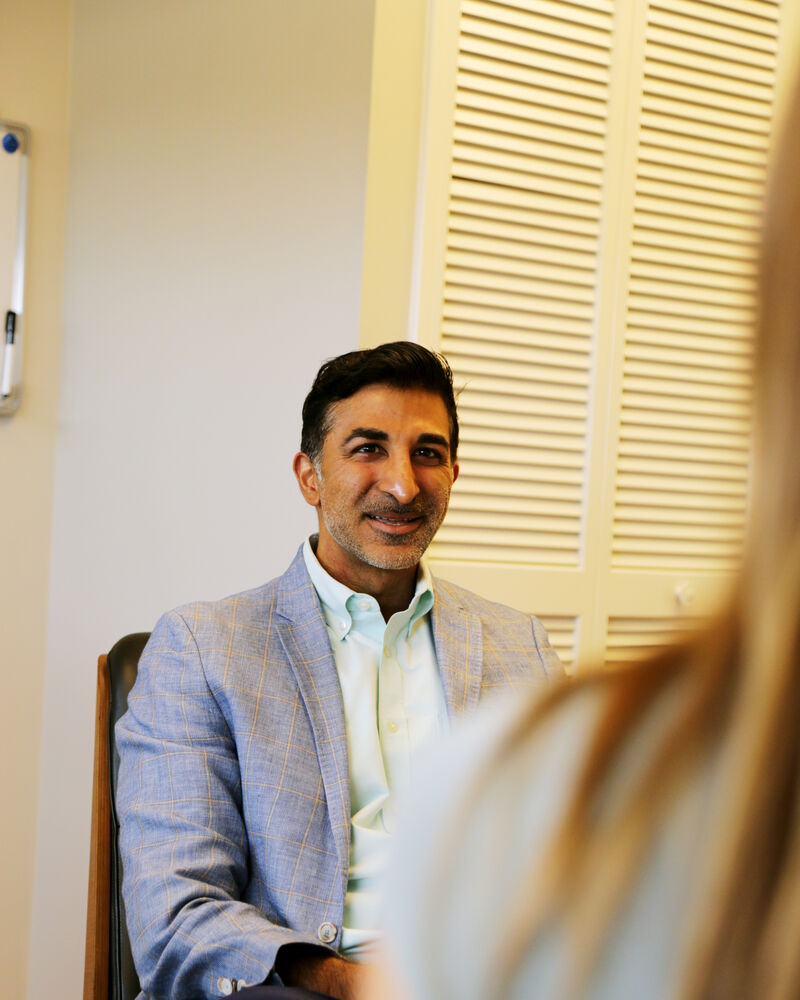 Dr. Loungani talking with a patient in his office
